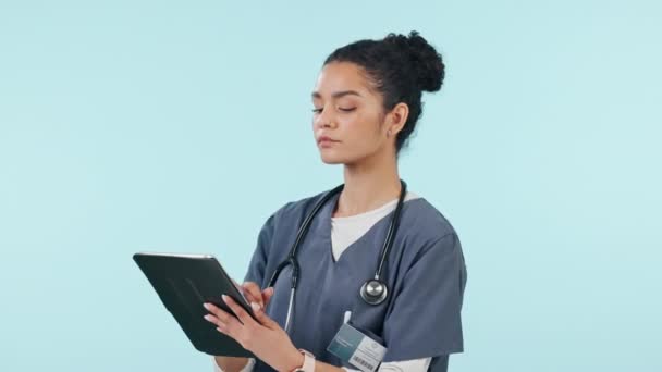 Nurse, woman thinking and tablet with healthcare solution, data analysis and results for online medical service in studio. Doctor or student on digital tech for ideas or decision on blue background. - Footage, Video