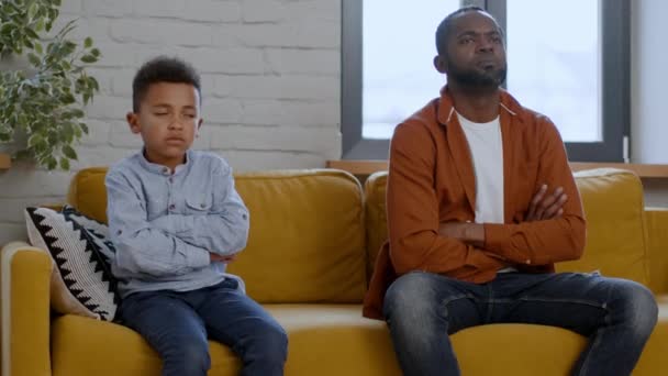Gyerekek és szülők közti szakadék. Bántotta az afro-amerikai apát és a fiatalkorú fiát, akik a kanapén ültek, egymásra néztek, és egymás után fordultak vissza, a szabad térben. - Felvétel, videó
