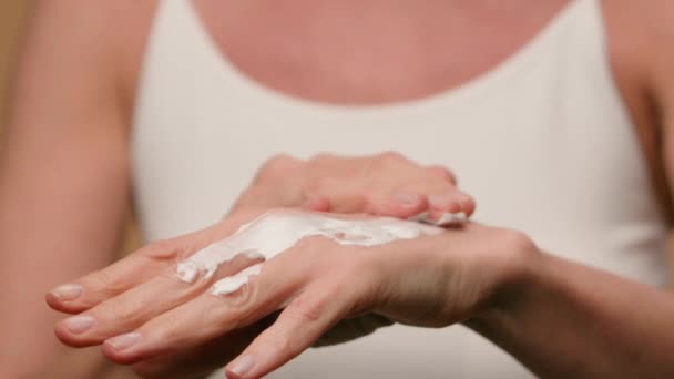 Közelkép női ráncos kezek érett idős nő alkalmazása hidratáló krém természetes szépség anti-aging bőr kozmetikumok emelés testápoló lágy hidratálja a napi kezelés száraz bőr tenyér kozmetológia - Felvétel, videó