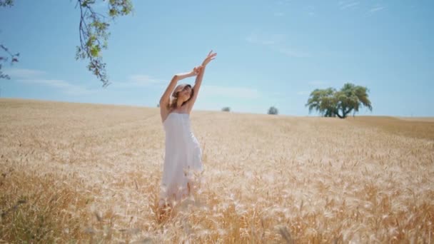 Witte jurk model zomer genieten op ontbijtgranen natuur. Jonge vrouw met opgeheven armen poserend aan de horizon van het rogge veld. Brunette dame aanraken haar gevoel van vrijheid op de oogst landbouwgrond landschap. Landelijk leven  - Video