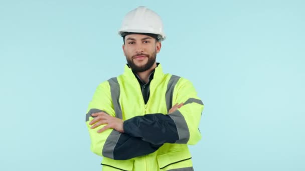 Yüz, mühendis ve kolları miğferli bir adam stüdyoda mavi arka plan modelleme alanında izole edilmiş. Portre, mimar ve kendine güvenen profesyonel, Brezilya 'da inşaat işi için şapkalı. - Video, Çekim