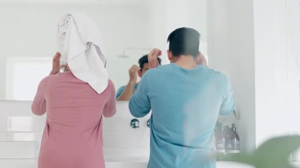 Back, hair and morning with a couple in the bathroom together for a grooming routine in their home. Mirror, health or beauty with a man and woman getting ready while grooming for skincare in a house. - Footage, Video