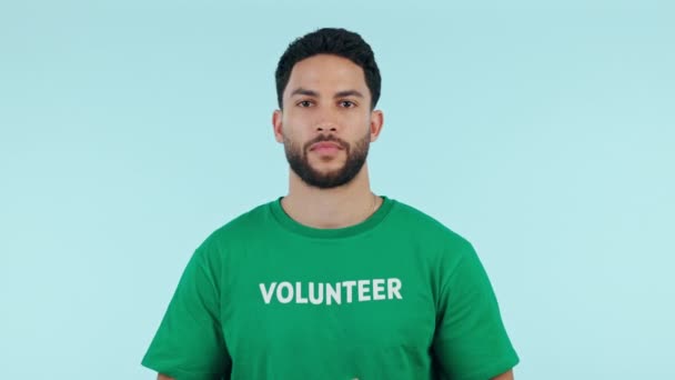Smile, happy man or volunteer finger gun, fun or excited for nonprofit studio, humanitarian support or community service. Activist kindness, eco charity foundation or portrait wink on blue background. - Footage, Video