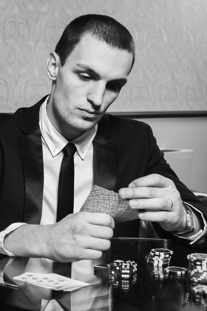 Ο άνθρωπος που παίζει πόκερ στο τραπέζι του πόκερ. - Φωτογραφία, εικόνα