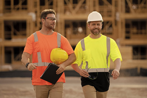 two architect men have construction project on clipboard. photo of architect men with construction project. architect men with construction project. architect men at construction project outdoor. - Foto, Imagem