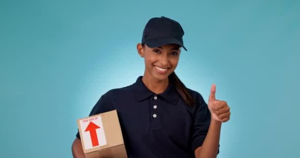 Happy woman, delivery and box with thumbs up in success or winning against a studio background. Portrait of female person or courier lady smile with like emoji, yes sign or OK in logistics or package. - Footage, Video
