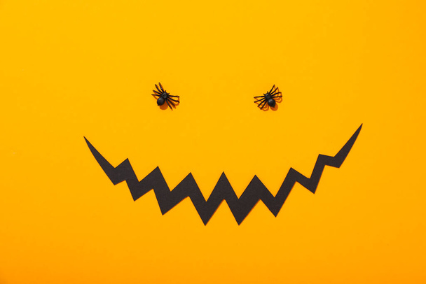 Διακοσμητικές αράχνες και χάρτινο στόμα σε κίτρινο φόντο, κορυφαία άποψη - Φωτογραφία, εικόνα