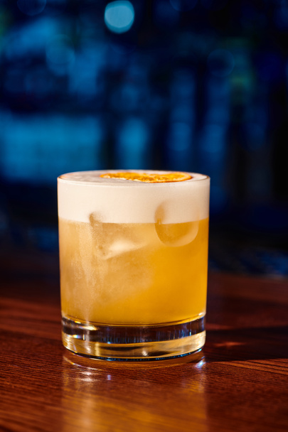 jeges pohár csípős whisky savanyú citromos díszítéssel bárral a háttérben, koncepció - Fotó, kép