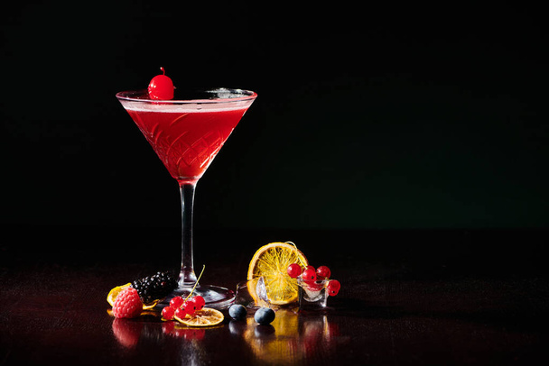 virkistävä kosmopoliittinen koristeltu cocktail kirsikka mustalla pohjalla, käsite - Valokuva, kuva