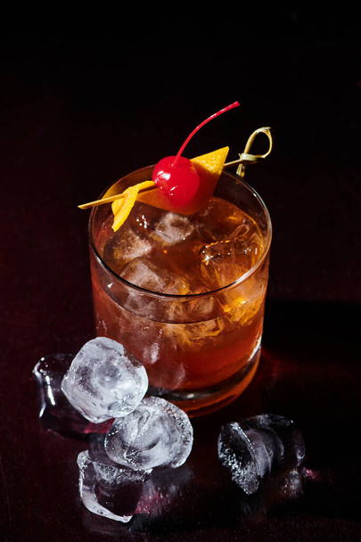 thirst quenching negroni with cocktail cherry and ice cubes on black backdrop, concept - Photo, Image