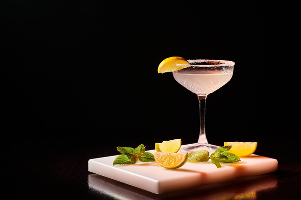 ice cold glass of delicious margarita garnished with slice of lime on bar counter, concept - Photo, Image