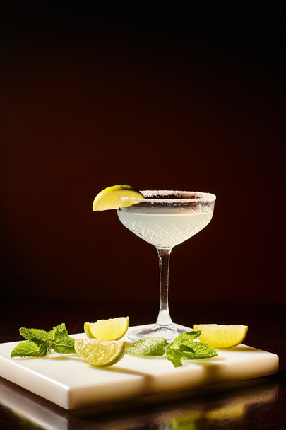 eiskaltes Glas anspruchsvoller Margarita mit Limettenscheibe auf schwarzem Hintergrund, Konzept - Foto, Bild
