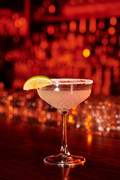 sophisticated margarita cocktail garnished with lime slice and ice on bar counter, concept - Photo, Image
