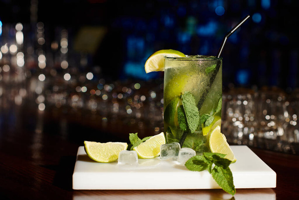 ice cold elegant mojito cocktail decorated with mint and lime on bar backdrop, concept - Photo, Image