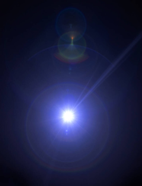 Deslumbramiento sobre un fondo negro. Una cámara apuntando a la luz produce un efecto de destello especial. Un rayo de sol y un espectro de colores del arco iris. Brillos y gradientes. Ilusión óptica - Foto, imagen