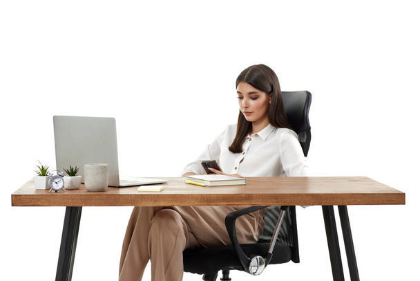 beautiful businesswoman working with laptop and using phone on white background - Φωτογραφία, εικόνα