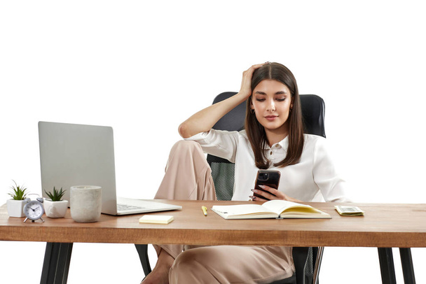beautiful happy female manager working with laptop and using phone on white background - Valokuva, kuva