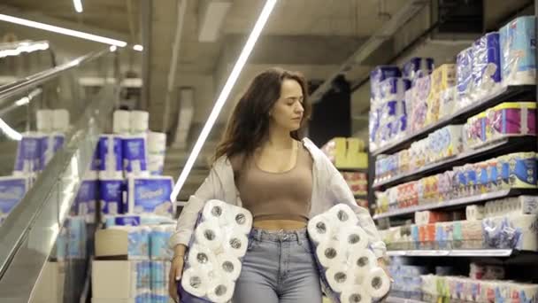 Uma jovem a comprar um pacote de papel higiénico num supermercado. Produtos de higiene. - Filmagem, Vídeo