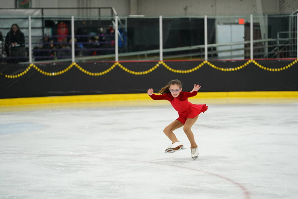 Mosinee, Wisconsin États-Unis - 26 février 2021 : Femme adulte dans une belle robe rouge a participé à la compétition de patinage sur glace des jeux d'hiver de l'État du blaireau - Photo, image