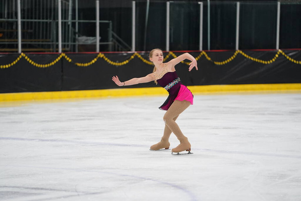 Мосідін, штат Вісконсин США 26 лютого 2021 року: Доросла жінка в красивій червоній сукні взяла участь у змаганнях з зимового катання на ковзанах - Фото, зображення