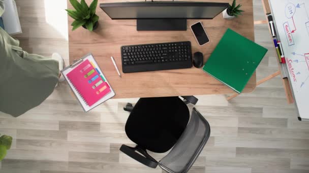 pracovní den, mladá zaměstnankyně pracuje v počítači vyplňuje papírování, zatímco sedí v kanceláři, horní pohled - Záběry, video