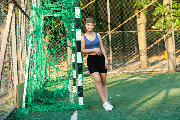 Athletic young woman in sportswear jogging in the park. Fitness and healthy lifestyle. Portrait of a beautiful young woman in sportswear outdoors. Sport fitness model caucasian ethnicity training outdoor. - Foto, Imagem