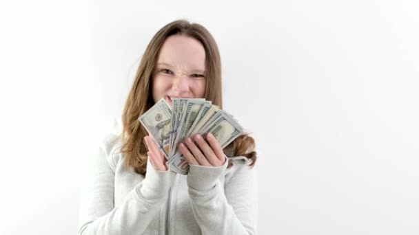 show off a large amount of money young teenage girl shows a whole wad of money steal take from parents make money. on white background in studio 100 dollar. bills and a young woman - Footage, Video
