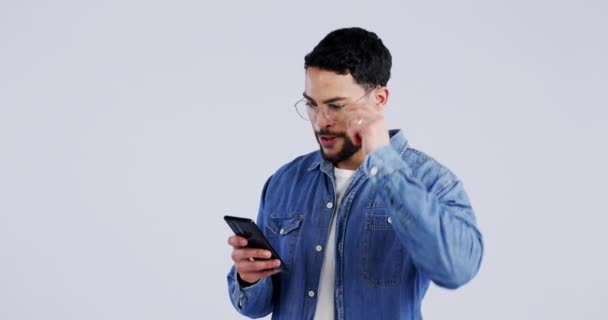 Meme, surprise or man excited by phone notification in studio for online bonus or fashion sale. Glasses, shock or happy person on blue background for mobile app promotion, message or good news. - Footage, Video