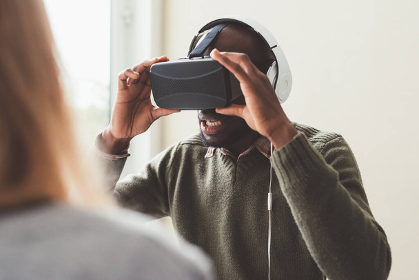 Hombre negro interior utilizando visor 3d - videojuegos, realidad aumentada, concepto de tecnología wereable - Foto, imagen