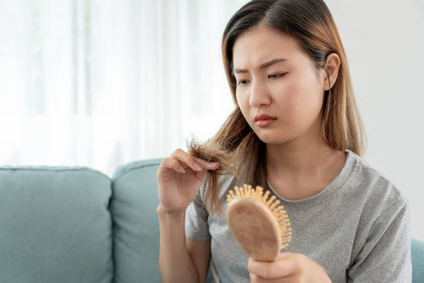 Aasian nainen hyvin surullinen ja järkyttynyt katsomalla vaurioitunut hiukset, hiustenlähtö, hiustenlähtö ongelma, vitamiinin puutos, kaljuuntuminen, synnytyksen jälkeen, biotiini, sinkki, kuukautiset tai hormonaaliset häiriöt, hormonaalinen epätasapaino - Valokuva, kuva