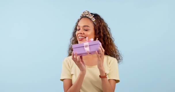 Heyecanlı, kadın titreşimli hediye ve kutu stüdyoda mavi arka planda izole edilmiş. Portre, mutlu insan hediye paketi ve parti, doğum günü kutlaması ve hediye kazananı.. - Video, Çekim