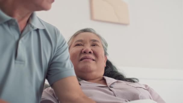 Gekippte Aufnahme eines älteren Mannes, der seine kranke Frau an der Hand hält, sich um sie kümmert und Zeit miteinander zu Hause verbringt - Filmmaterial, Video