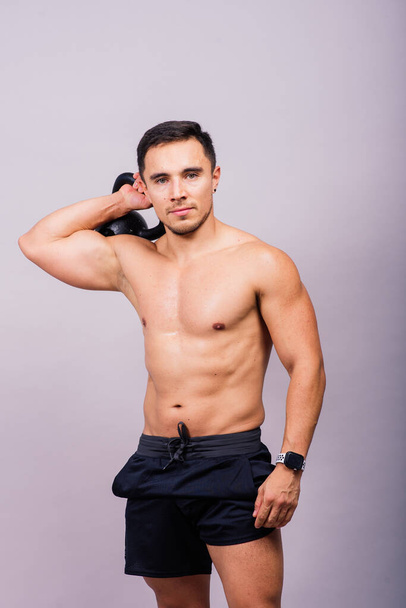 Полное тело мускулистого человека, тренирующегося с гантелями на белом и темном фоне - Фото, изображение