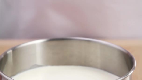Egy fazékba öntik folyékony tejszín - Felvétel, videó