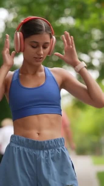 Młoda kobieta w sportowej odzieży spogląda na smartfona przed bieganiem. Wysokiej jakości materiał 4k - Materiał filmowy, wideo