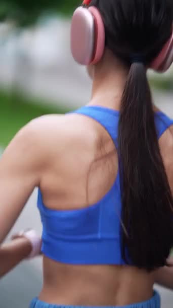 Rondlopend door de straten van de stad, een jong meisje in atletische kleding wordt gezien van achteren. Hoge kwaliteit 4k beeldmateriaal - Video