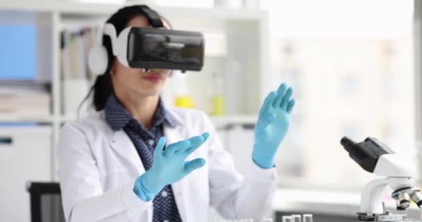 Vrouwelijke arts traint om operatie uit te voeren met behulp van virtual reality bril in lichte kliniek. Begrip technologie en moderne opleiding van stagiairs slow motion - Video