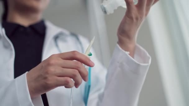 Prise de vue à faible angle du travailleur médical préparant un compteur de gouttes pour l'intervention chez un patient malade en clinique - Séquence, vidéo