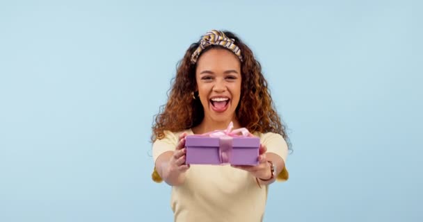 Подарок, возбужденная женщина и указание на коробку в студии, изолированную на голубом фоне макетным пространством. Портрет, счастливый человек, дающий подарок на вечеринке или праздновании дня рождения победителя вручения приза. - Кадры, видео