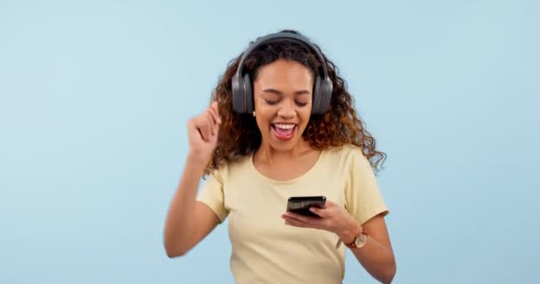 Танці, мобільні телефони та жінка з навушниками в студії. текстове повідомлення або мережа в соціальних мережах. Щаслива, посмішка та жіноча модель Прослуховування музики та прокручування в Інтернеті на білому тлі - Кадри, відео
