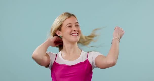 Sorriso, capelli e vento con una donna su uno sfondo blu in studio cercando felice con il suo trattamento shampoo. Ritratto, crescita e cura dei capelli con un giovane modello che sente la brezza in un salone di lusso. - Filmati, video