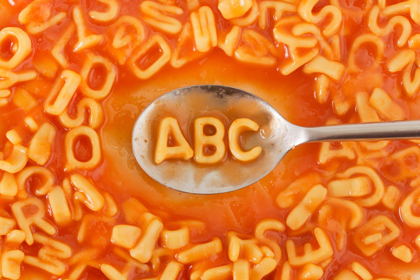 トマトソースをスプーンで Abc の文字の形をしたパスタ  - 写真・画像