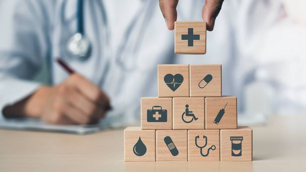 Концепція страхування для вашого здоров'я, Рука тримає дерев'яний блок з іконою медичного
 - Фото, зображення