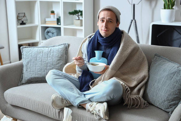Ill young man eating soup at home - Photo, Image