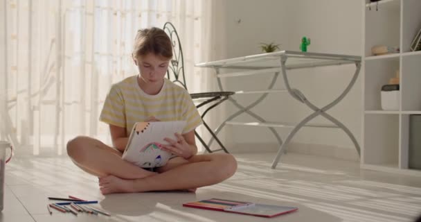 Imagination vive dévoilée : Voyage à travers l'art coloré au crayon avec une adolescente dans sa demeure. Images 4k de haute qualité - Séquence, vidéo