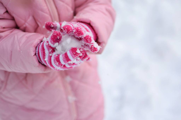 dítě v bílé bundě drží růžovou sněhovou vločku - Fotografie, Obrázek