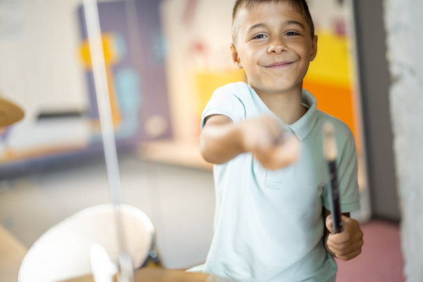 Mały chłopiec gra na prawdziwych bębnach, bawi się podczas zwiedzania muzeum nauki - Zdjęcie, obraz
