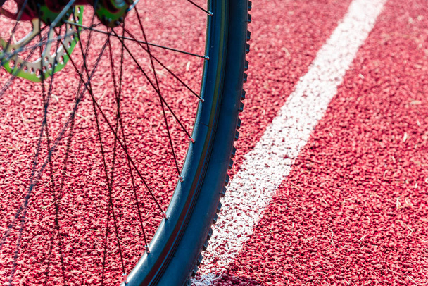 Велосипедист на дороге. Байкер на велосипеде по пути зрения сверху на красной дорожке background.Close. - Фото, изображение