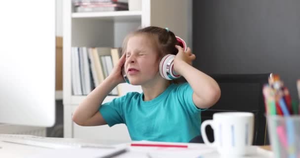 Little girl with headphones listening to music and typing on computer keyboard 4k movie. Online education for children concept - Footage, Video