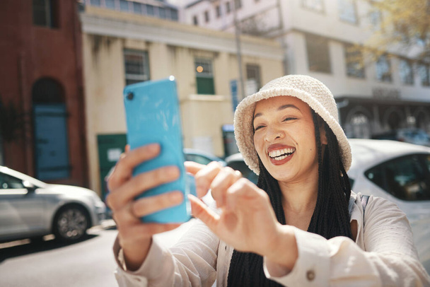 Happy woman on street with phone, live streaming in city and travel holiday blog for social media post. Influencer, streamer or gen z girl with urban fashion, smartphone and smile in content creation. - Photo, Image
